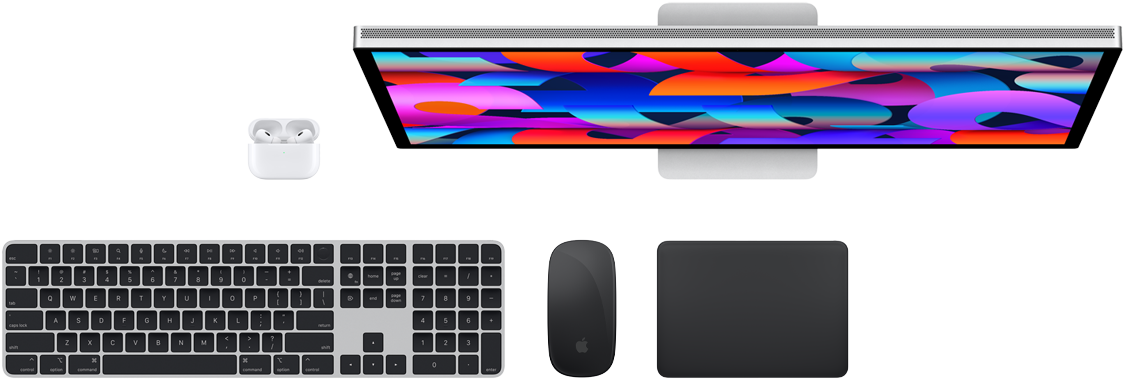Vista superior de varios accesorios del Mac: un Studio Display, unos AirPods, un Magic Keyboard, un Magic Mouse y un Magic Trackpad.