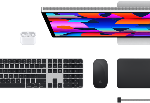 Vista superior de varios accesorios del Mac: un Studio Display, un Magic Keyboard, un Magic Mouse, un Magic Trackpad, unos AirPods y un cable de carga MagSafe